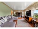Inviting living room boasts a stone fireplace, hardwood floors, and large windows with scenic views at 8701 Majestic View Dr, Conifer, CO 80433