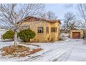 Ranch home with a snow-covered yard and attached garage at 3780 Benton St, Wheat Ridge, CO 80212