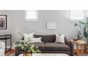 Comfortable living room featuring a brown couch, stylish pillows, and minimalist decor for a relaxed atmosphere at 1025 E Iowa Ave, Denver, CO 80210