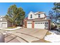 Two-story house with a brick facade and attached two car garage at 317 Ingleton Ct, Castle Pines, CO 80108