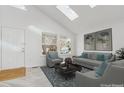 Bright living room with skylights, neutral furniture, and large windows at 9057 Bermuda Run Cir, Highlands Ranch, CO 80130