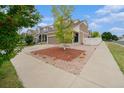 View of a two-story home highlighting the front yard with wood-chip landscaping and a young tree at 5550 Malta St, Denver, CO 80249