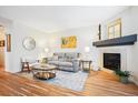 A welcoming living room featuring a cozy fireplace, hardwood floors, and comfortable seating at 8520 S Holland Ln # 102, Littleton, CO 80128