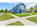 Stylish blue home with a well-kept lawn and a welcoming walkway to the front door at 3178 N Race St, Denver, CO 80205