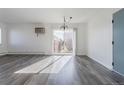 Spacious living room with grey laminate flooring and large sliding glass doors leading to a balcony at 5995 W Hampden Ave # 17C, Denver, CO 80227