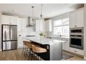 Modern kitchen with white cabinets, a large island, and stylish backsplash at 10270 E 62Nd Pl, Denver, CO 80238