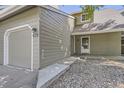 Traditional townhome featuring a two-car garage, classic siding, and welcoming entryway at 10685 W Apishapa Pass, Littleton, CO 80127