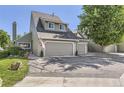 A well-maintained townhome with a two-car garage, patriotic flag, and manicured front lawn at 10685 W Apishapa Pass, Littleton, CO 80127