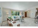 Comfortable living room with large window, plush seating, and staircase access at 7877 W 110Th Dr, Westminster, CO 80021