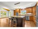 Bright kitchen featuring wood cabinets, a granite-topped island, and stainless steel appliances at 7655 S Olive Cir, Centennial, CO 80112