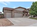 Charming single Gathering home boasting a three car garage and covered porch entryway at 5131 Delphinium Cir, Brighton, CO 80601