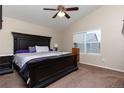 The main bedroom features a dark wood king bed, ceiling fan, and natural lighting at 5131 Delphinium Cir, Brighton, CO 80601