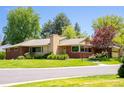 Street view of a brick home with a well-kept lawn and mature trees at 6600 E 4Th Ave, Denver, CO 80220