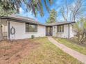 Inviting single-story home with a stone pathway, a front yard with trees, and a well-maintained lawn at 755 S Milwaukee St, Denver, CO 80209