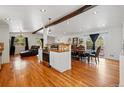 Open living space with hardwood floors connecting a modern kitchen, dining area, and comfortable lounge at 11715 W 30Th Pl, Lakewood, CO 80215