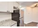 Kitchen featuring stainless steel refrigerator, granite countertops, and bright white cabinetry at 909 S Dawson Way # 2, Aurora, CO 80012
