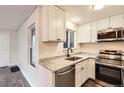 Modern kitchen featuring sleek stainless-steel appliances, granite countertops, and bright white cabinetry at 909 S Dawson Way # 2, Aurora, CO 80012