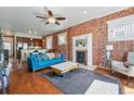 Bright living room boasts exposed brick wall, fireplace, and hardwood floors at 1438 N Franklin St # 100, Denver, CO 80218
