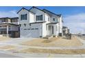 Two-story farmhouse-style home with white siding, gray accents, and a two-car garage at 9204 Truckee Ct, Commerce City, CO 80022