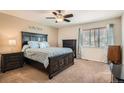 Comfortable bedroom featuring a ceiling fan, large window, and dark wood furniture, creating a relaxing atmosphere at 20336 E 48Th Dr, Denver, CO 80249