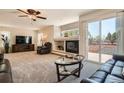 Spacious living room with a cozy fireplace and sliding glass doors to the outside at 20336 E 48Th Dr, Denver, CO 80249