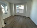 Bright and airy bedroom featuring wood floors, white walls, and large windows offering plenty of natural light at 5546 Inland Ave, Firestone, CO 80504