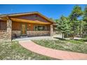 Charming home featuring a stone-clad facade and a welcoming front porch at 18150 Martingale Rd, Monument, CO 80132