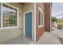 Close-up of the front entrance showcasing the blue door, brick facade, and window at 2705 S Danube Way # 110, Aurora, CO 80013