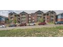 View of apartments with brick exterior and balconies and multiple parked cars lining the street at 2705 S Danube Way # 110, Aurora, CO 80013
