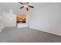 Spacious living room featuring neutral carpet, ceiling fan, and open layout to the kitchen at 2705 S Danube Way # 110, Aurora, CO 80013