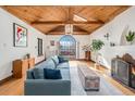 Inviting living room featuring wood ceilings, fireplace and large window at 2646 Colorado Blvd, Denver, CO 80207