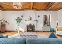 Inviting living room featuring a fireplace, hardwood floors, and a distinctive wood-paneled ceiling at 2646 Colorado Blvd, Denver, CO 80207