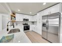 Modern kitchen features white cabinets, stainless steel appliances, and quartz countertops at 6631 S Cedar St, Littleton, CO 80120