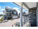 A gray two-story home featuring a brick driveway, a gray front exterior and a stone balcony at 4443 N Quatar Ct, Aurora, CO 80019