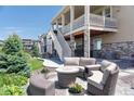 Backyard patio area with stone tile, outdoor seating, and a landscaped yard at 8761 S Wenatchee Ct, Aurora, CO 80016