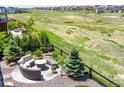 Relaxing backyard view featuring a fire pit with seating, lush greenery and a private fence at 8761 S Wenatchee Ct, Aurora, CO 80016