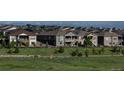 A serene neighborhood street view showcasing well-maintained homes and green spaces against a backdrop of snow-capped mountains at 8761 S Wenatchee Ct, Aurora, CO 80016