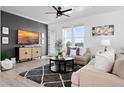 Modern living room with stylish decor, hardwood floors, a large TV, and comfortable seating at 12261 Farmview St, Thornton, CO 80241