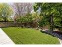 Spacious backyard featuring lush artificial grass, mature trees, and a wooden fence at 420 N Colorado Blvd, Denver, CO 80206