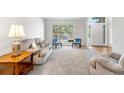 Cozy living room with large windows offering ample natural light, plush seating and neutral carpeting at 3102 White Oak Trl, Highlands Ranch, CO 80129