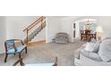 Bright living room showcasing neutral carpet, staircase and an archway leading to the dining area at 3102 White Oak Trl, Highlands Ranch, CO 80129
