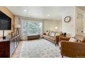 Bright living room featuring a large window, leather seating, and modern decor at 1811 S Yank Ct, Lakewood, CO 80228