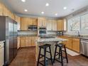 Modern kitchen with stainless steel appliances, center island with granite countertops, and tile floors at 3309 Springbriar Dr, Castle Rock, CO 80109