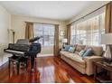 Cozy living room featuring hardwood floors, sofa, piano, and window with lots of natural light at 3309 Springbriar Dr, Castle Rock, CO 80109