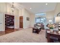 Bright living room featuring high ceilings, large windows, and a view into the library at 3462 W 109Th Cir, Westminster, CO 80031