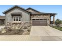 Charming home exterior with stone accents, a two-car garage, and a well-maintained front yard at 3477 New Haven Cir, Castle Rock, CO 80109
