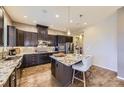 Modern kitchen boasts granite counters, stainless steel appliances, dark cabinets, and hardwood floors at 3477 New Haven Cir, Castle Rock, CO 80109