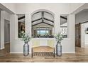 Warm and welcoming foyer featuring wood floors, a decorative bench, and views into the living spaces at 16312 Morning Rise Ln, Monument, CO 80132