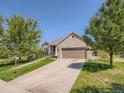 View of the home featuring well manicured lawn and mature trees on a bright day at 7746 S Valdai Ct, Aurora, CO 80016