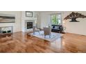 Cozy living room with hardwood floors, a fireplace, and a large window offering natural light at 7746 S Valdai Ct, Aurora, CO 80016